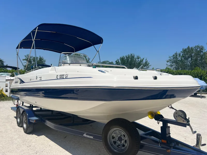 Slide: The Image of 2007 Hurricane 231 boat on trailer with blue canopy. - 2