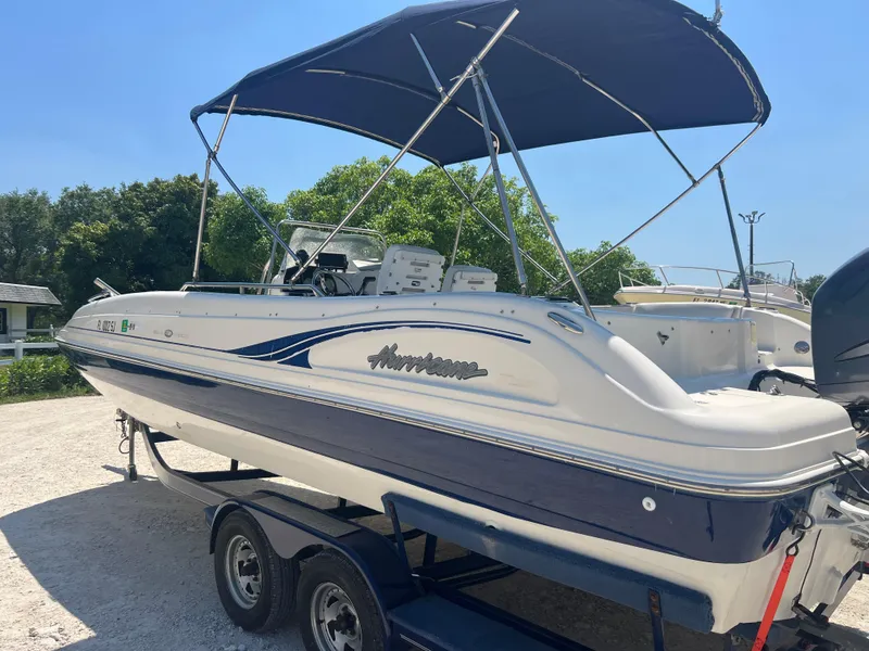Slide: The Image of 2007 Hurricane 231 boat with blue and white exterior on a trailer. - 28