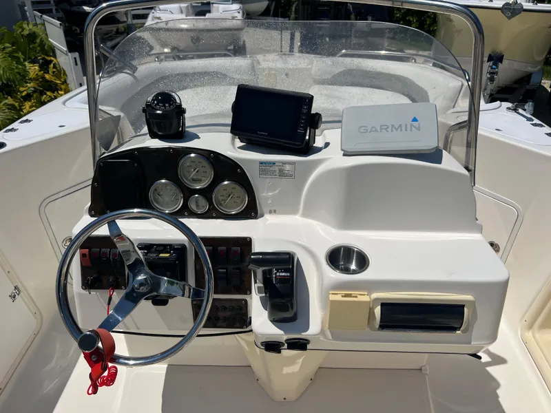Slide: The Image of 2007 Hurricane 231 boat dashboard with Garmin GPS, steering wheel, and control panel. - 37