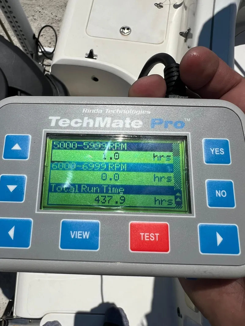 Slide: The Image of Hand holding TechMate Pro diagnostic tool displaying engine run time data for 2007 Hurricane 231 boat. - 49