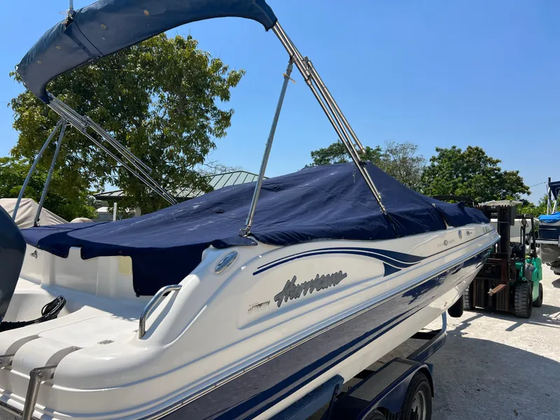 Slide: The Image of 2007 Hurricane 231 boat with blue cover and canopy in sunny outdoor setting. - 7