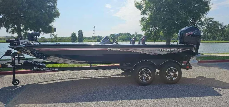 Slide: The Image of 2024 Ranger RT198P fishing boat on trailer by a lake. - 0