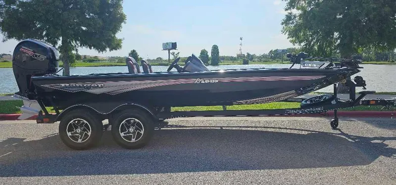 Slide: The Image of 2024 Ranger RT198P fishing boat on a trailer by a lake. - 1