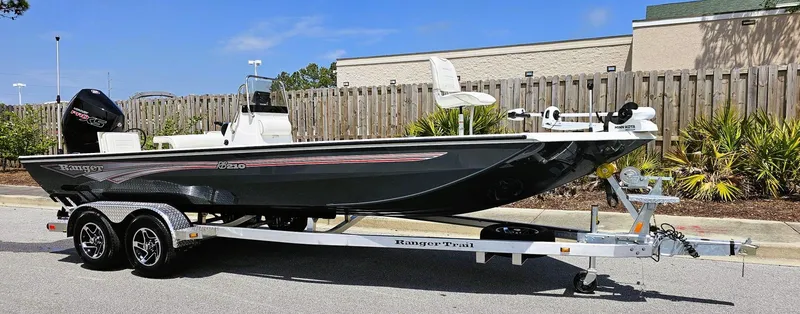 Slide: The Image of 2024 Ranger RB210 boat on a trailer, parked outdoors. - 2