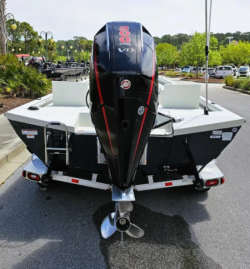 Slide: The Image of 2024 Ranger RB210 boat with powerful outboard motor, parked on a trailer in a sunny lot. - 6