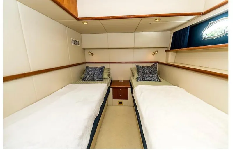 Slide: The Image of Twin cabin interior of 1997 Sunseeker Manhattan yacht with cozy beds and elegant decor. - 16