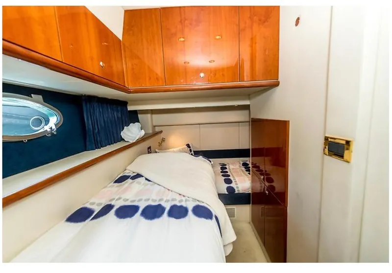 Slide: The Image of Cozy cabin interior of 1997 Sunseeker Manhattan yacht with wooden cabinets and porthole window. - 17