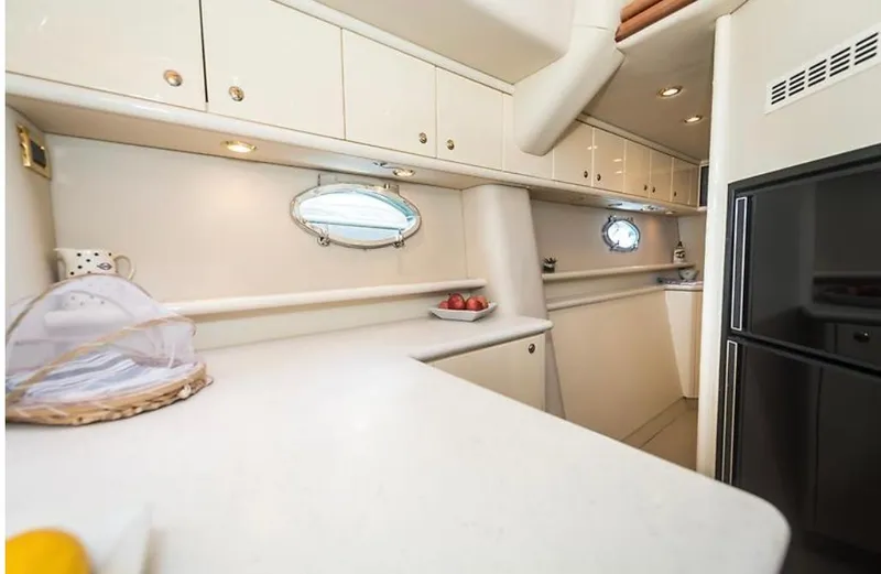 Slide: The Image of Luxurious 1997 Sunseeker MANHATTAN yacht kitchen with modern cabinetry and porthole windows. - 26