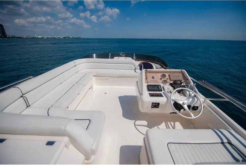 Slide: The Image of 1997 Sunseeker MANHATTAN yacht deck with white seating and steering, overlooking the ocean. - 39