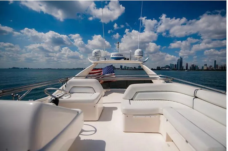 Slide: The Image of Sunseeker MANHATTAN 1997 yacht with city skyline, blue sky, and American flag. - 40