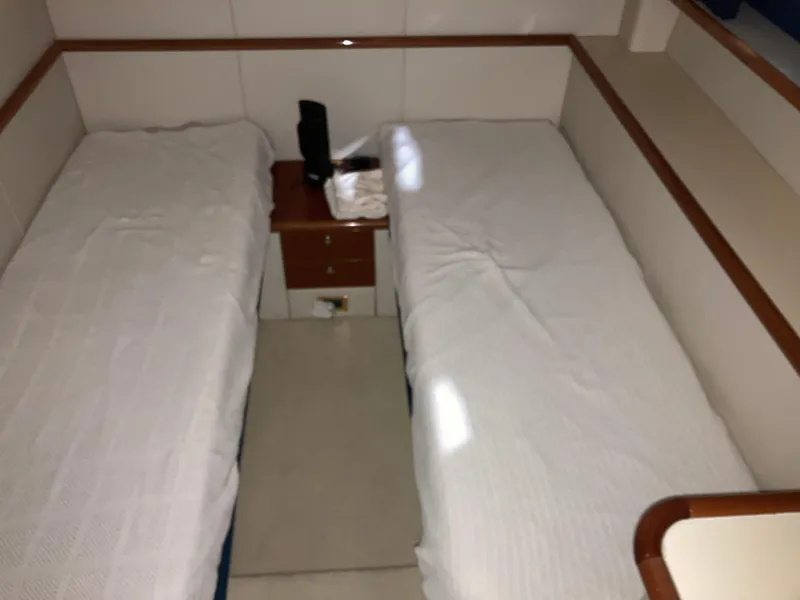 Slide: The Image of Twin beds in a 1997 Sunseeker MANHATTAN yacht cabin with a central nightstand. - 42