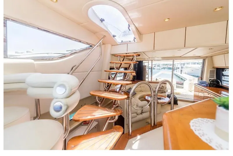 Slide: The Image of Luxurious interior of a 1997 Sunseeker Manhattan yacht with elegant wooden staircase and plush seating. - 8