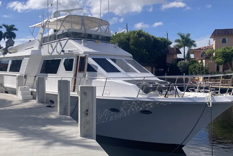 Slide: The Image of 1988 Viking 70 Cockpit Motor Yacht docked, surrounded by palm trees and clear skies. - 14