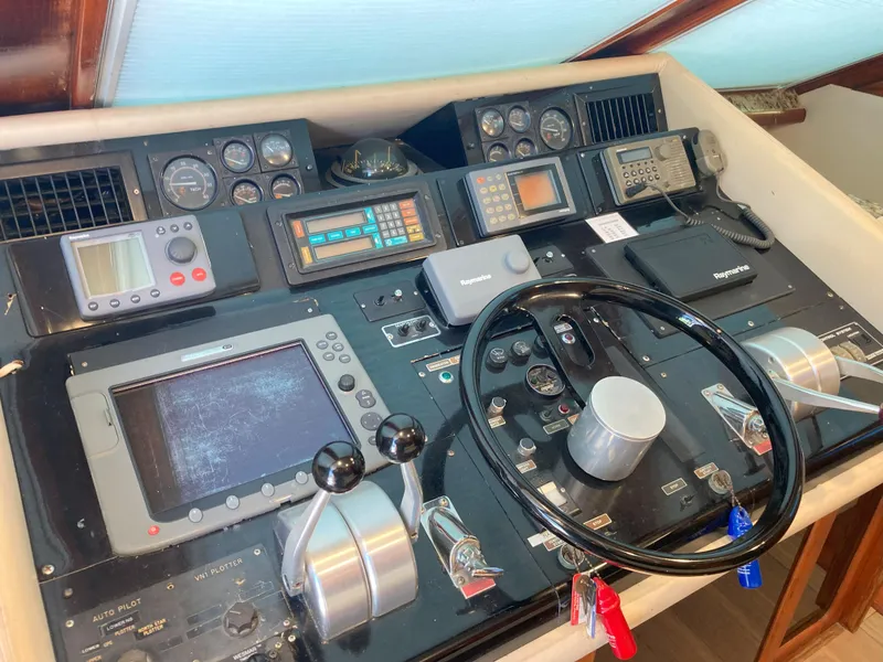 Slide: The Image of 1988 Viking 70 Cockpit Motor Yacht control panel with navigation instruments and steering wheel. - 17