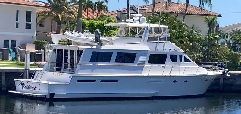 Slide: The Image of 1988 Viking 70 Cockpit Motor Yacht docked near waterfront homes. - 2