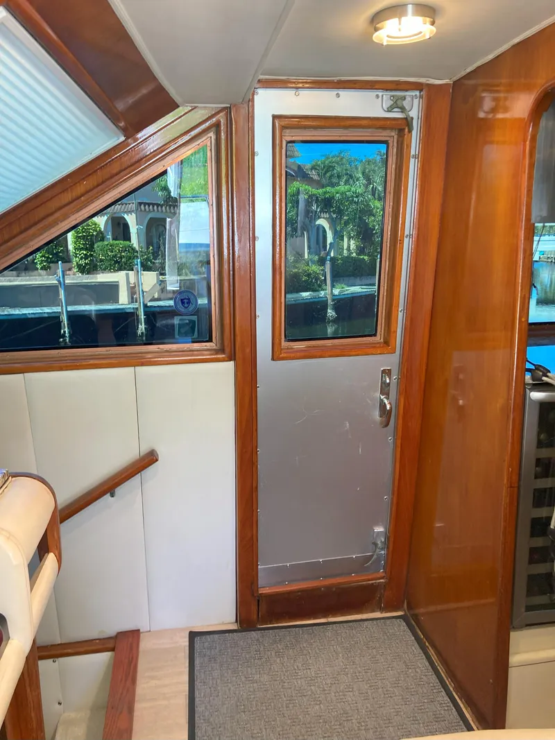 Slide: The Image of Interior view of 1988 Viking 70 Cockpit Motor Yacht with wooden finishes. - 24