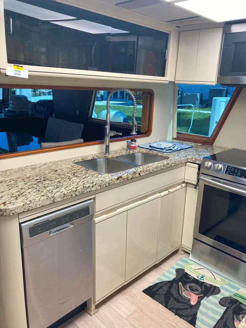 Slide: The Image of 1988 Viking 70 Cockpit Motor Yacht kitchen with granite countertops and stainless steel appliances. - 28