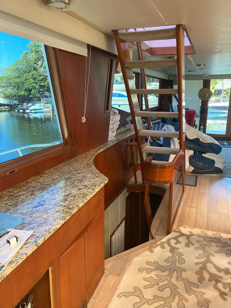 Slide: The Image of Interior of 1988 Viking 70 Cockpit Motor Yacht with wooden finishes and granite countertop. - 31