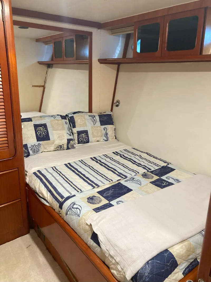 Slide: The Image of 1988 Viking 70 Cockpit Motor Yacht bedroom with nautical-themed bedding. - 42