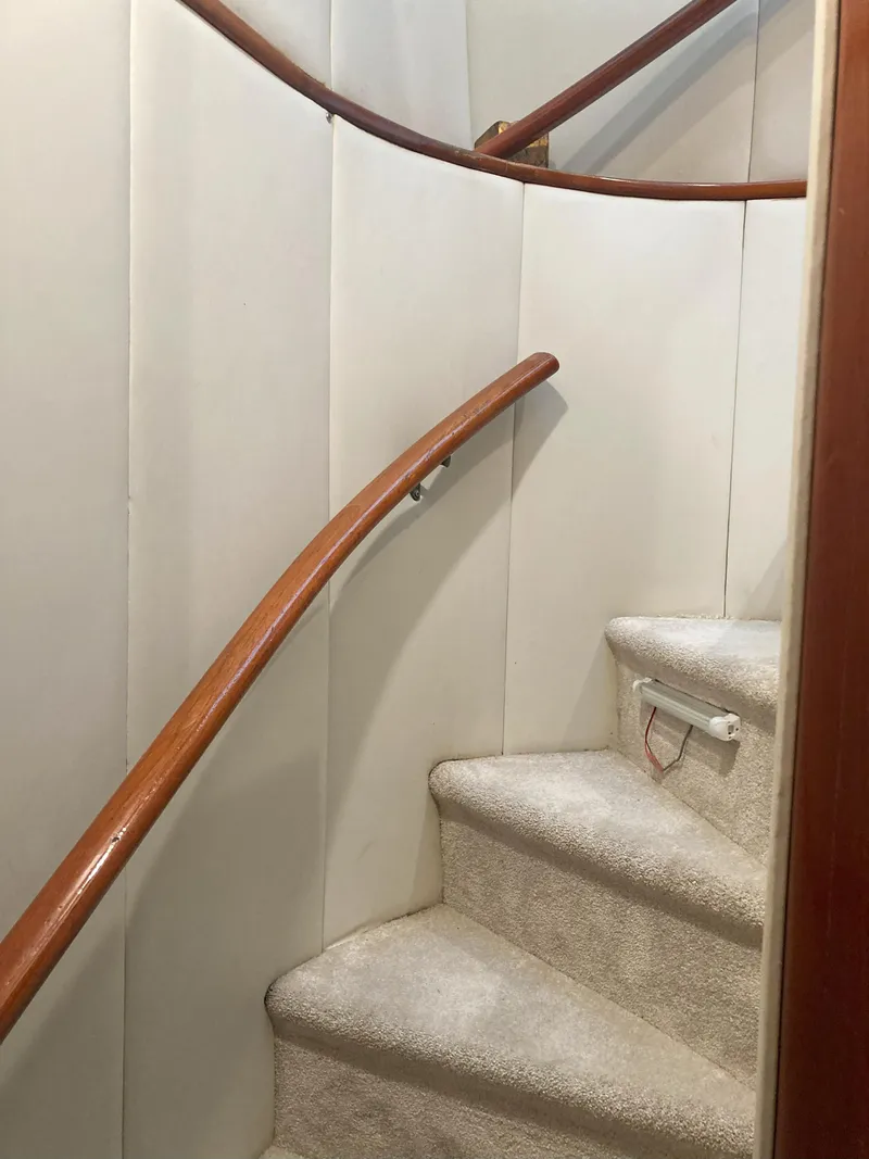 Slide: The Image of Staircase inside 1988 Viking 70 Cockpit Motor Yacht with wooden handrails. - 44