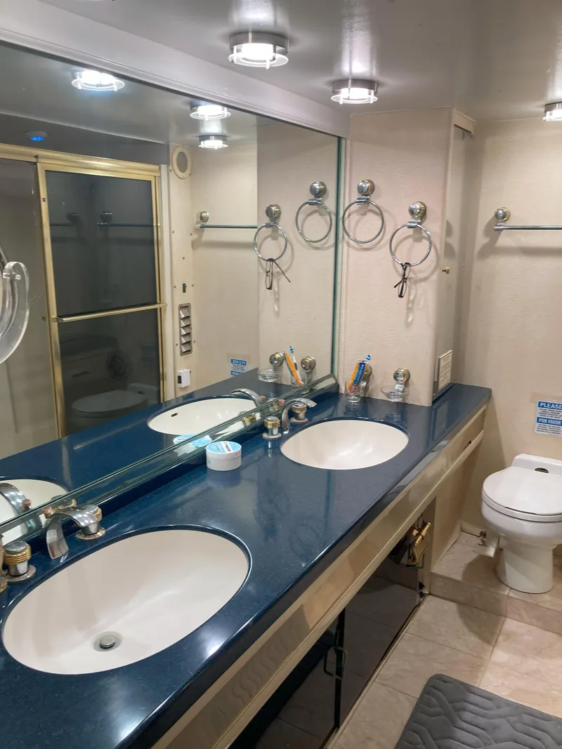 Slide: The Image of 1988 Viking 70 Cockpit Motor Yacht bathroom with double sinks and shower. - 49