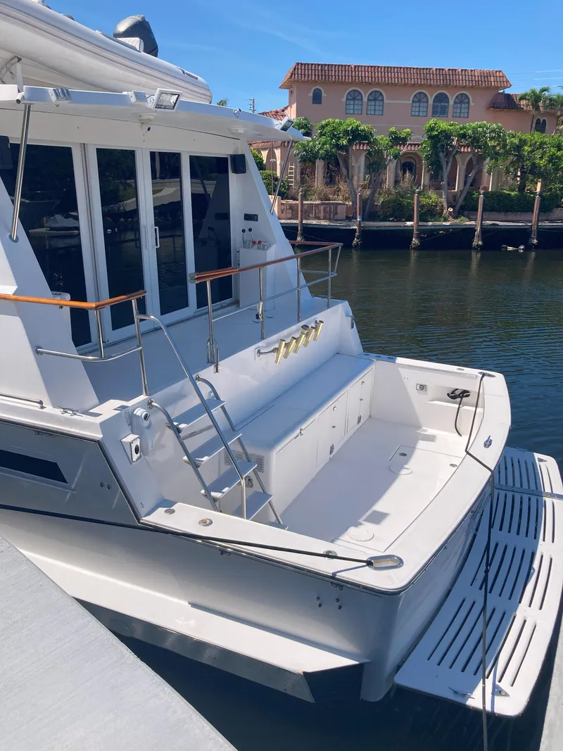 Slide: The Image of 1988 Viking 70 Cockpit Motor Yacht docked in a scenic waterfront location. - 7