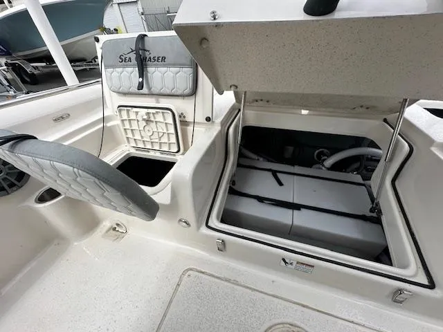 Slide: The Image of 2024 Carolina Skiff 23 LX boat interior with open storage compartments and seating. - 10