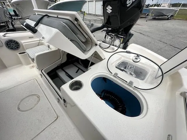 Slide: The Image of 2024 Carolina Skiff 23 LX boat interior with storage compartments and Suzuki outboard motor. - 11