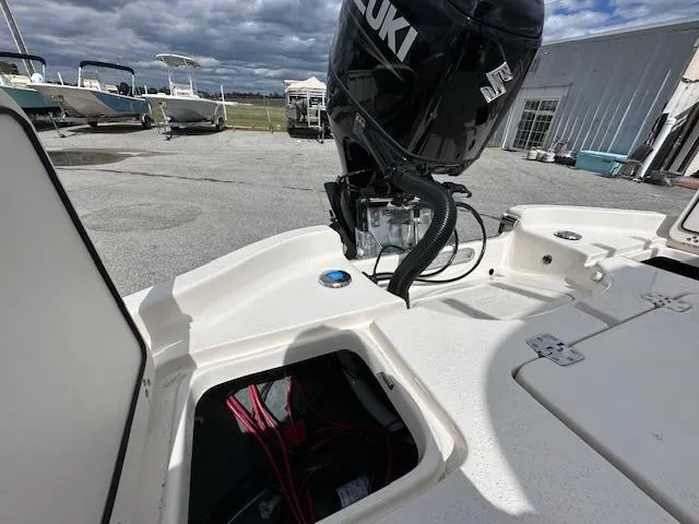 Slide: The Image of 2024 Carolina Skiff 23 LX boat with Suzuki outboard motor in a marina. - 8