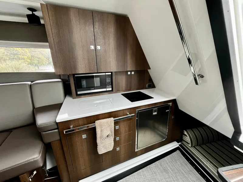 Slide: The Image of Modern kitchen area in 2018 Monterey 360 Sport Coupe yacht with microwave and sleek cabinetry. - 15