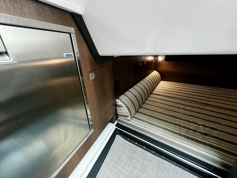 Slide: The Image of Interior cabin of 2018 Monterey 360 Sport Coupe with bed and stainless steel fridge. - 18