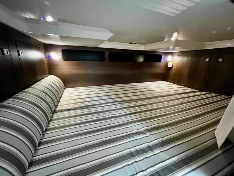 Slide: The Image of 2018 Monterey 360 Sport Coupe cabin with striped bedding and modern lighting. - 19