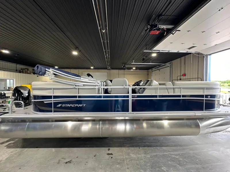 The Image of 2024 Starcraft LX22RDH pontoon boat in a garage. - 0