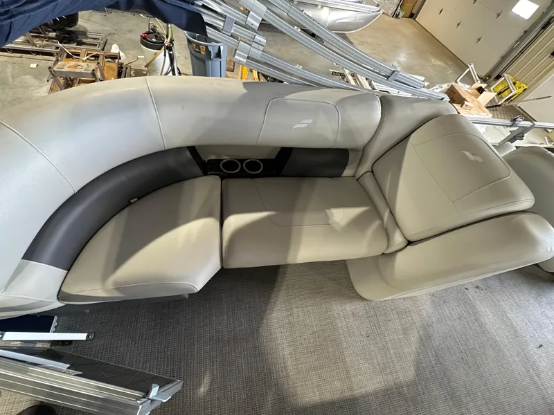 Slide: The Image of 2024 Starcraft LX22RDH boat interior with beige seating and cup holders. - 4