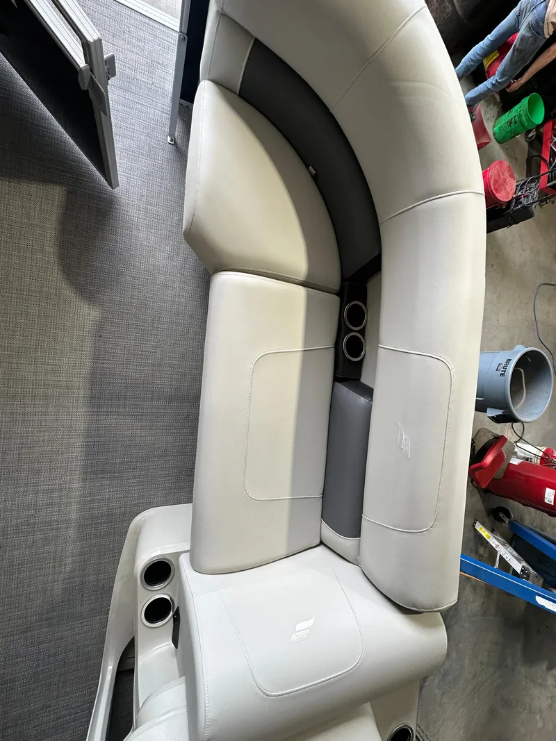 Slide: The Image of 2024 Starcraft LX22RDH boat interior with gray cushioned seating and cup holders. - 8