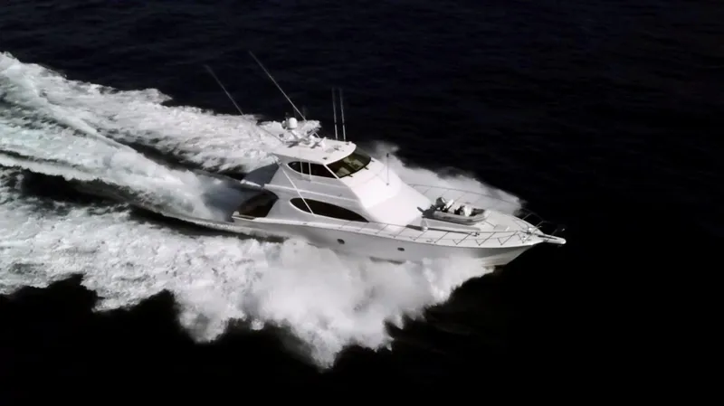 The Image of 2006 Hatteras Enclosed Bridge yacht cruising swiftly on open water. - 0