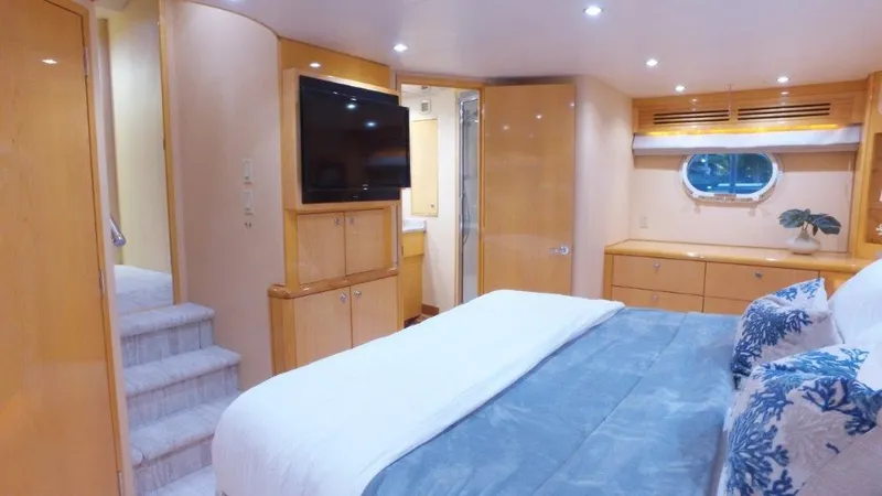 Slide: The Image of Luxurious 2006 Hatteras Enclosed Bridge yacht bedroom with modern decor and natural lighting. - 10