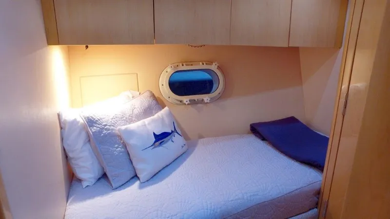 Slide: The Image of Cozy cabin interior of 2006 Hatteras Enclosed Bridge yacht with porthole and bedding. - 18