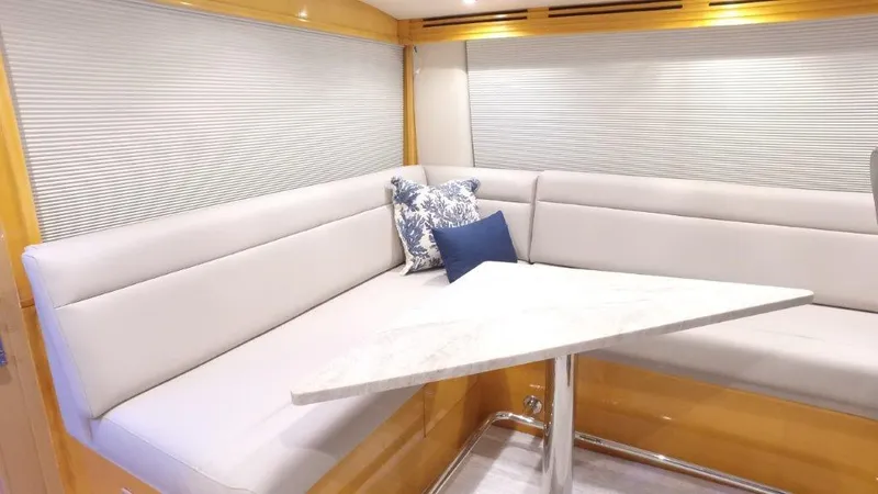 Slide: The Image of 2006 Hatteras Enclosed Bridge yacht interior with plush seating and decorative pillows. - 23