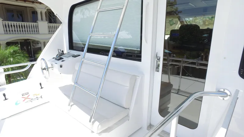 Slide: The Image of 2006 Hatteras Enclosed Bridge yacht with ladder and seating on deck. - 24