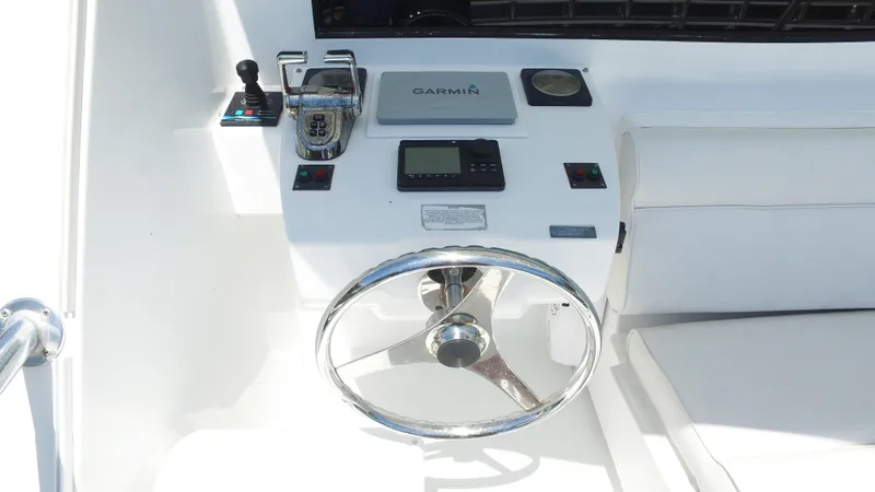 Slide: The Image of Helm of 2006 Hatteras Enclosed Bridge yacht with Garmin navigation system and steering wheel. - 25