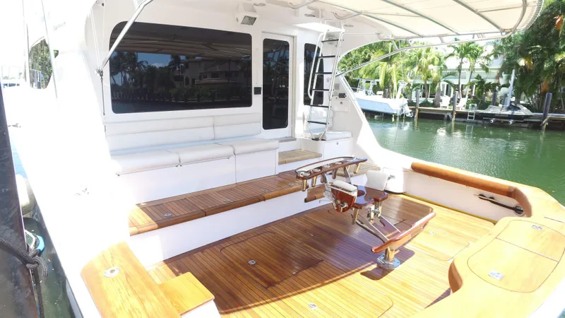 Slide: The Image of 2006 Hatteras Enclosed Bridge yacht with spacious teak deck and seating area by the water. - 26