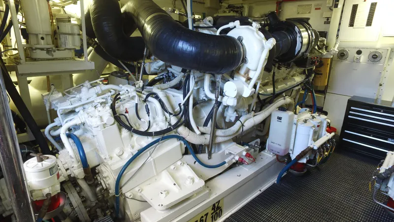 Slide: The Image of Engine room of a 2006 Hatteras Enclosed Bridge yacht, showcasing complex machinery and components. - 31