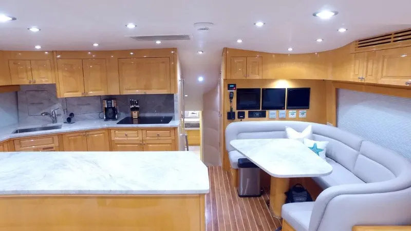 Slide: The Image of Luxurious interior of a 2006 Hatteras Enclosed Bridge yacht with modern kitchen and seating area. - 6