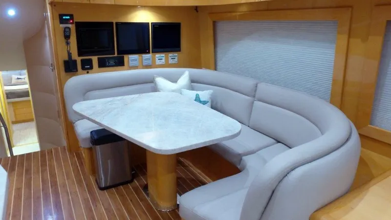 Slide: The Image of Luxurious 2006 Hatteras Enclosed Bridge yacht interior with curved seating and modern amenities. - 7