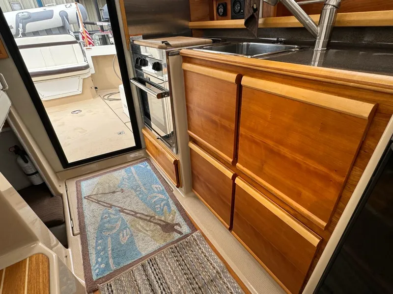 Slide: The Image of Interior of 2017 Cutwater C28 boat with wooden cabinetry and compact kitchen area. - 10