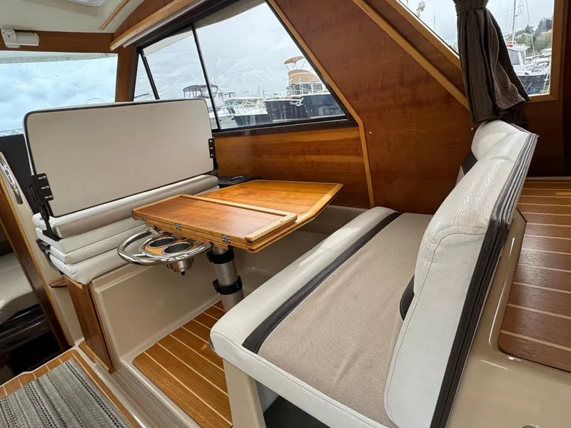 Slide: The Image of 2017 Cutwater C28 interior with wooden table and cushioned seating. - 11