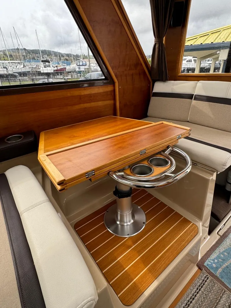 Slide: The Image of 2017 Cutwater C28 interior with wooden table, cushioned seating, and cup holders. - 14