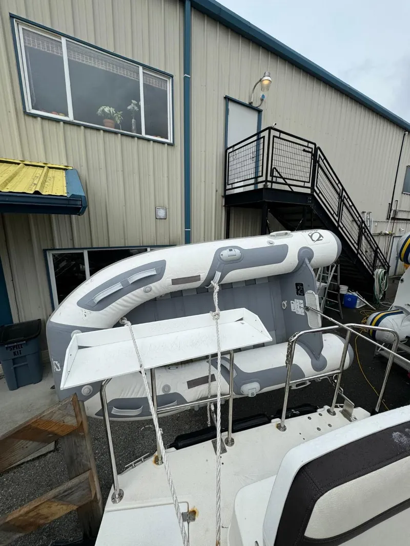 Slide: The Image of 2017 Cutwater C28 boat with inflatable dinghy, docked near a building with stairs. - 2