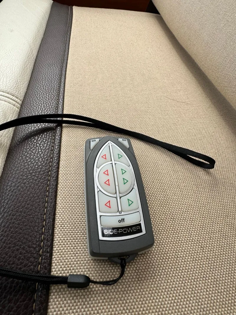 Slide: The Image of Remote control for Side-Power system on a 2017 Cutwater C28 boat, resting on beige upholstery. - 26
